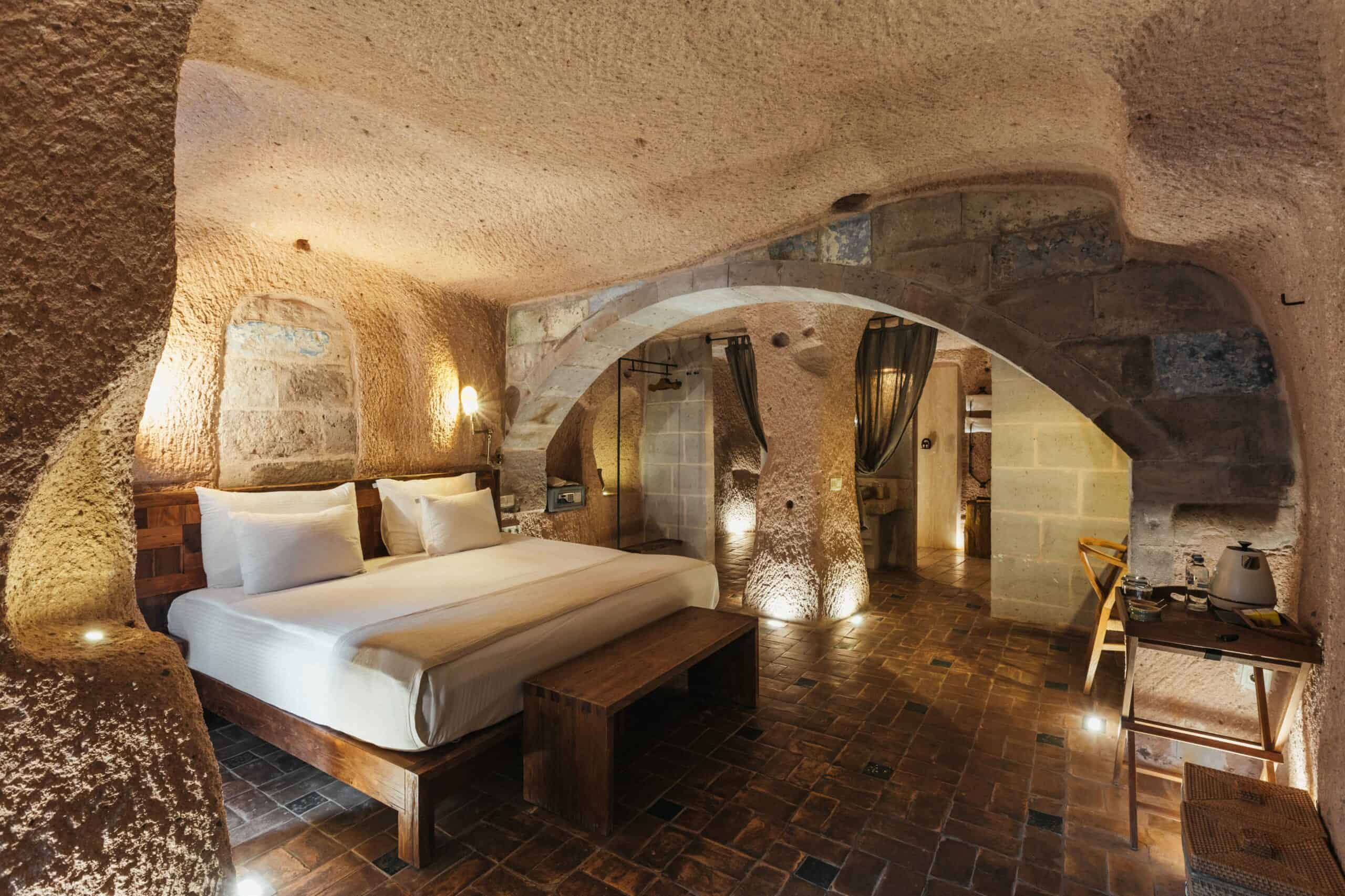 Junior Suite: cave room with double bed and stone arches