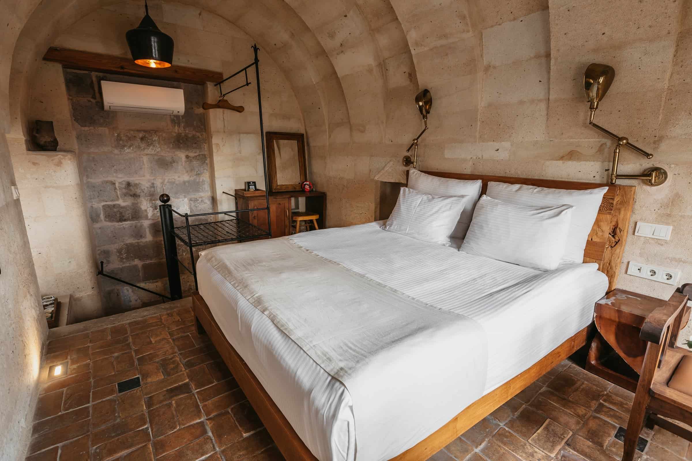 Standard Room: room with stone walls, arched niche and double bed