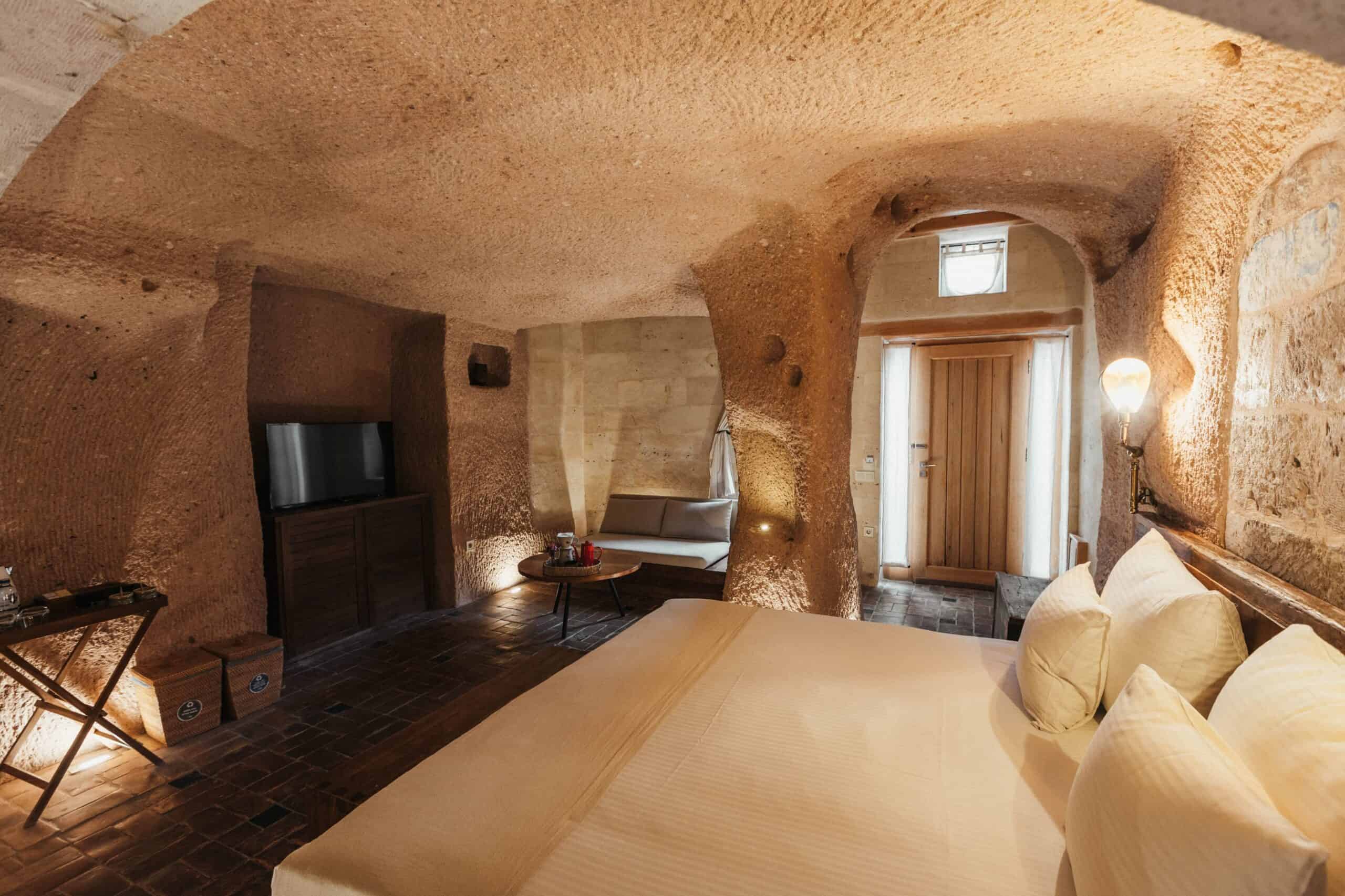 Junior Suite: cave room with double bed and carved stone walls