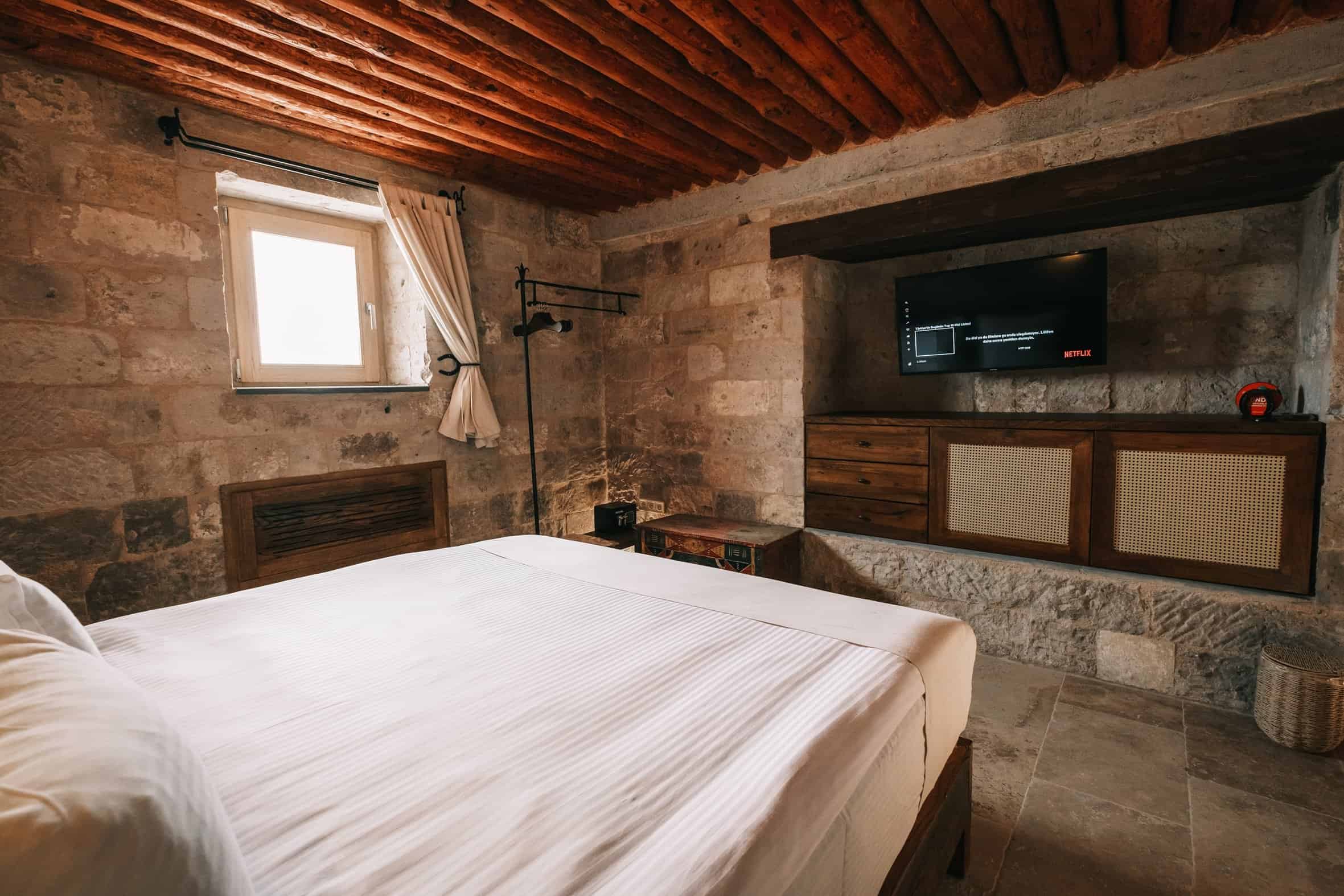 Standard Room: stone-walled room with wooden beamed ceiling and double bed