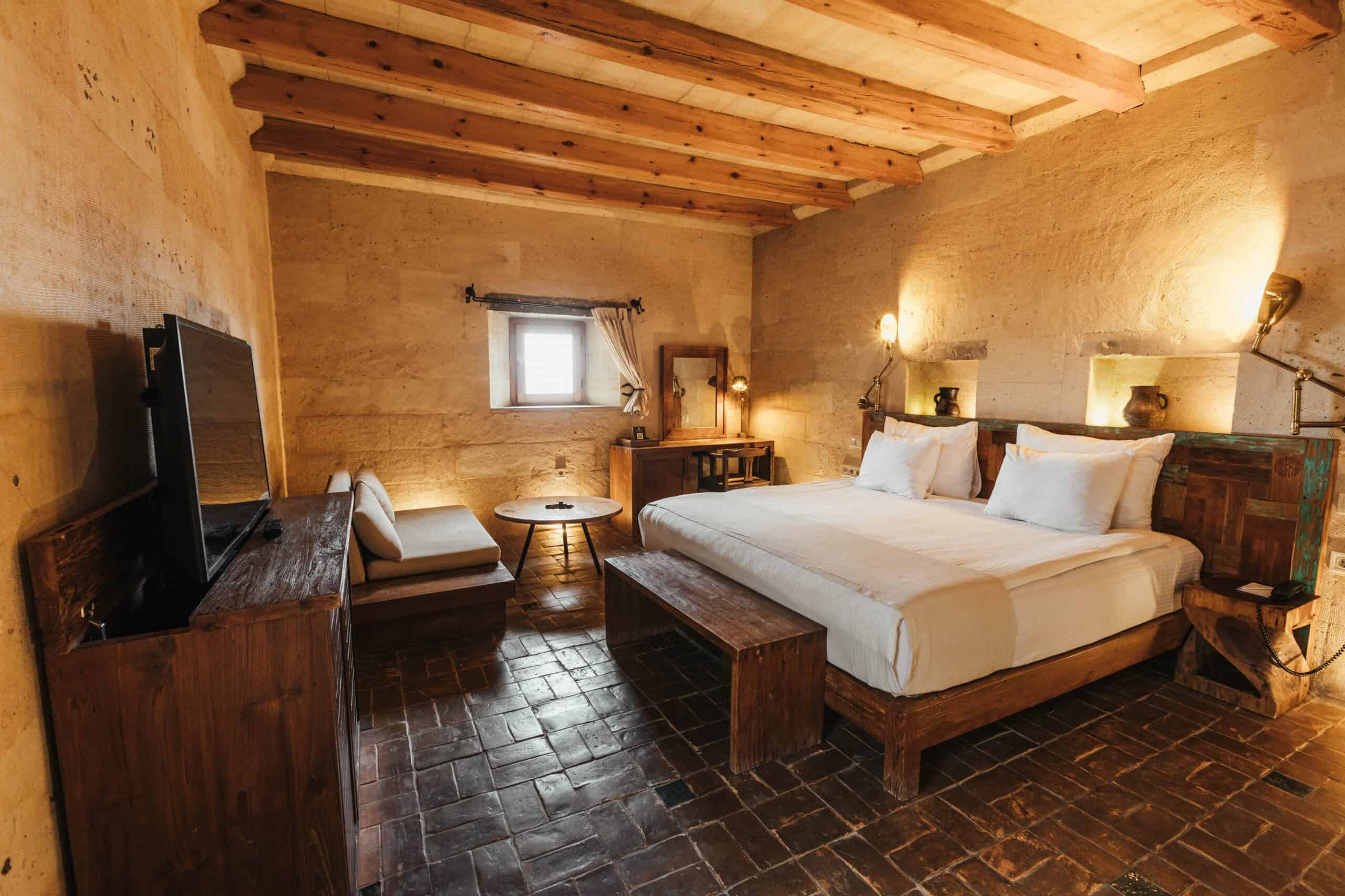 Junior Suite: cave room with double bed, wooden beamed ceiling and stone floor