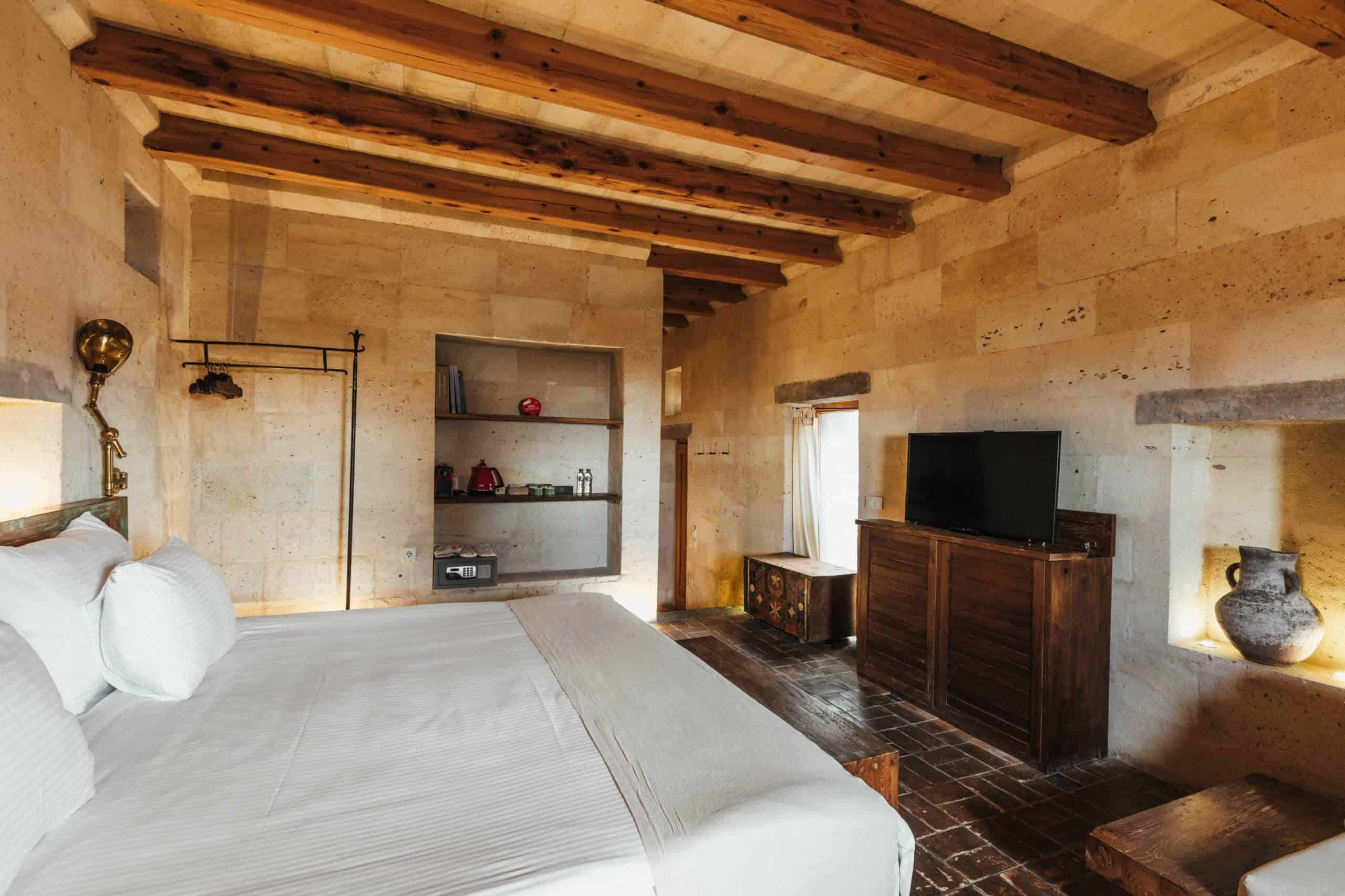 Junior Suite: bedroom with wooden ceiling beams and stone walls