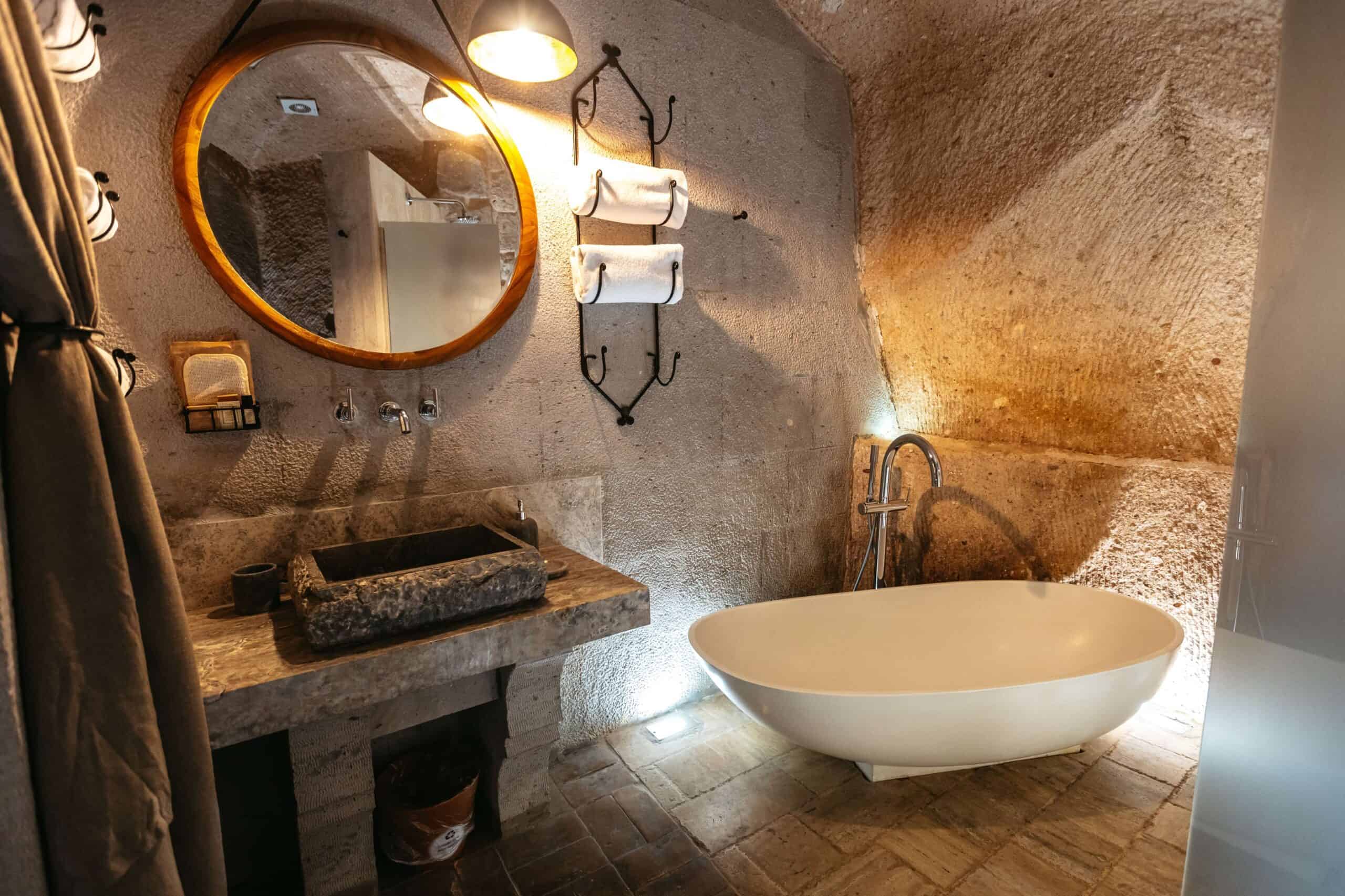 Junior Suite: cave bathroom with freestanding bathtub and stone sink