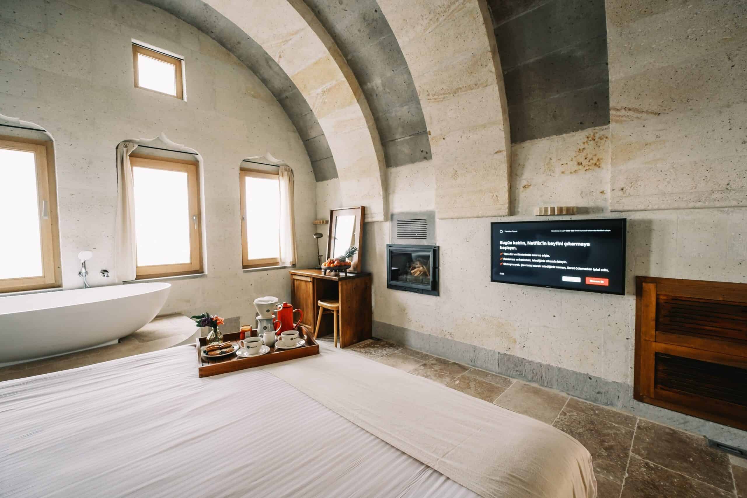 Vaulted room with bed, bathtub and windows