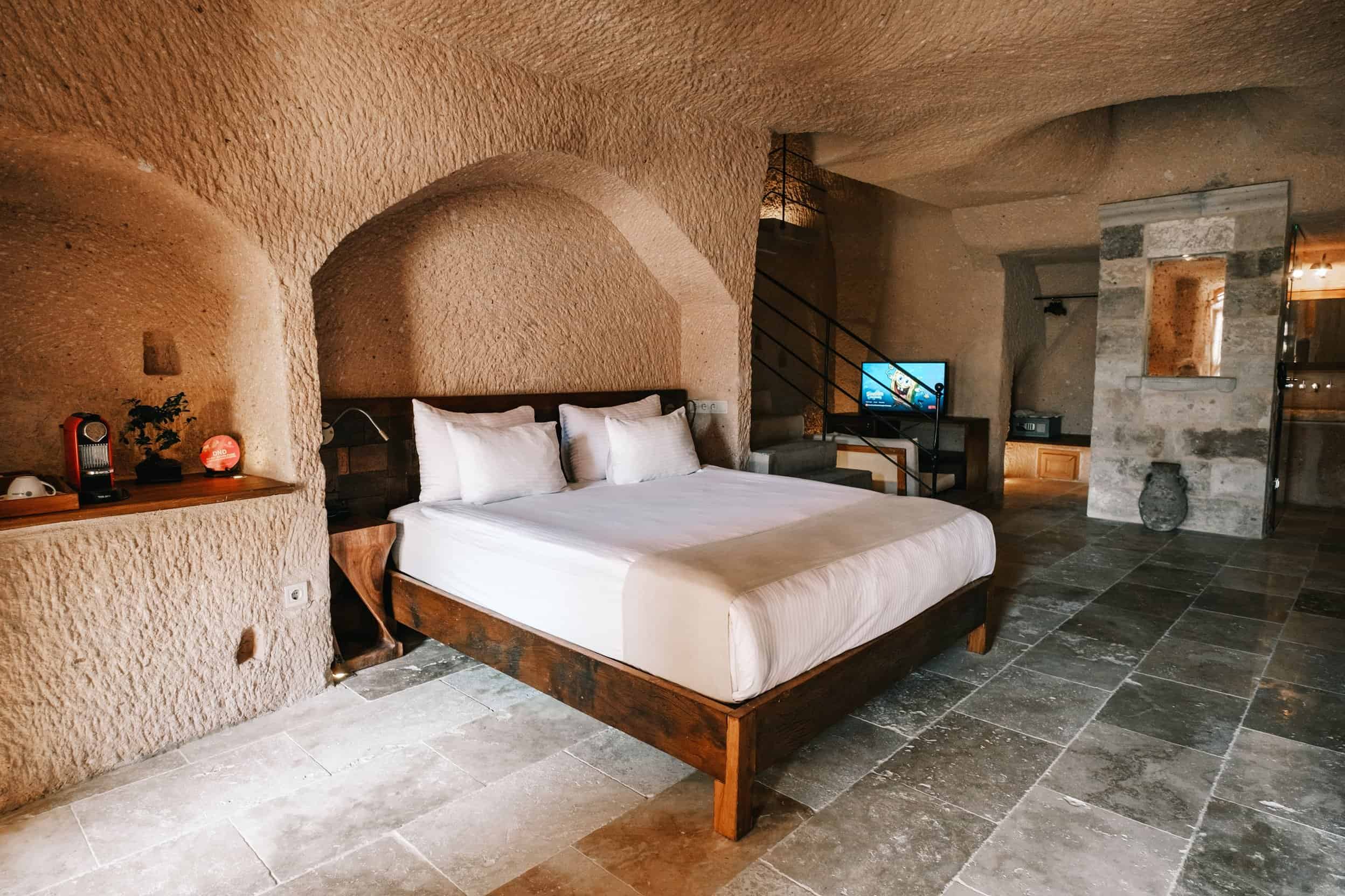 Superior King Suite: double bed in a stone cave room