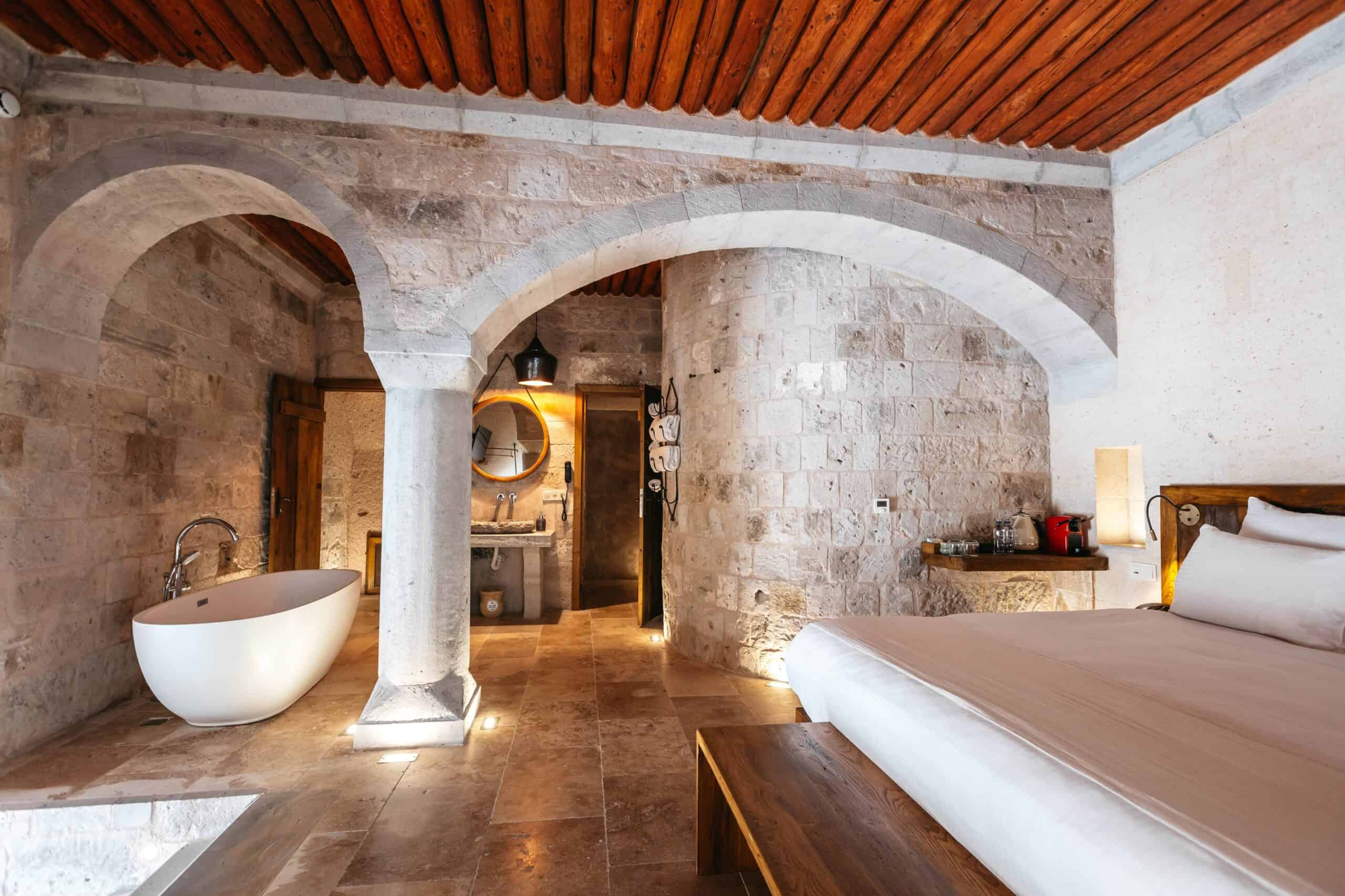 Semi-Open Pool Suite: freestanding bathtub, stone columns and double bed