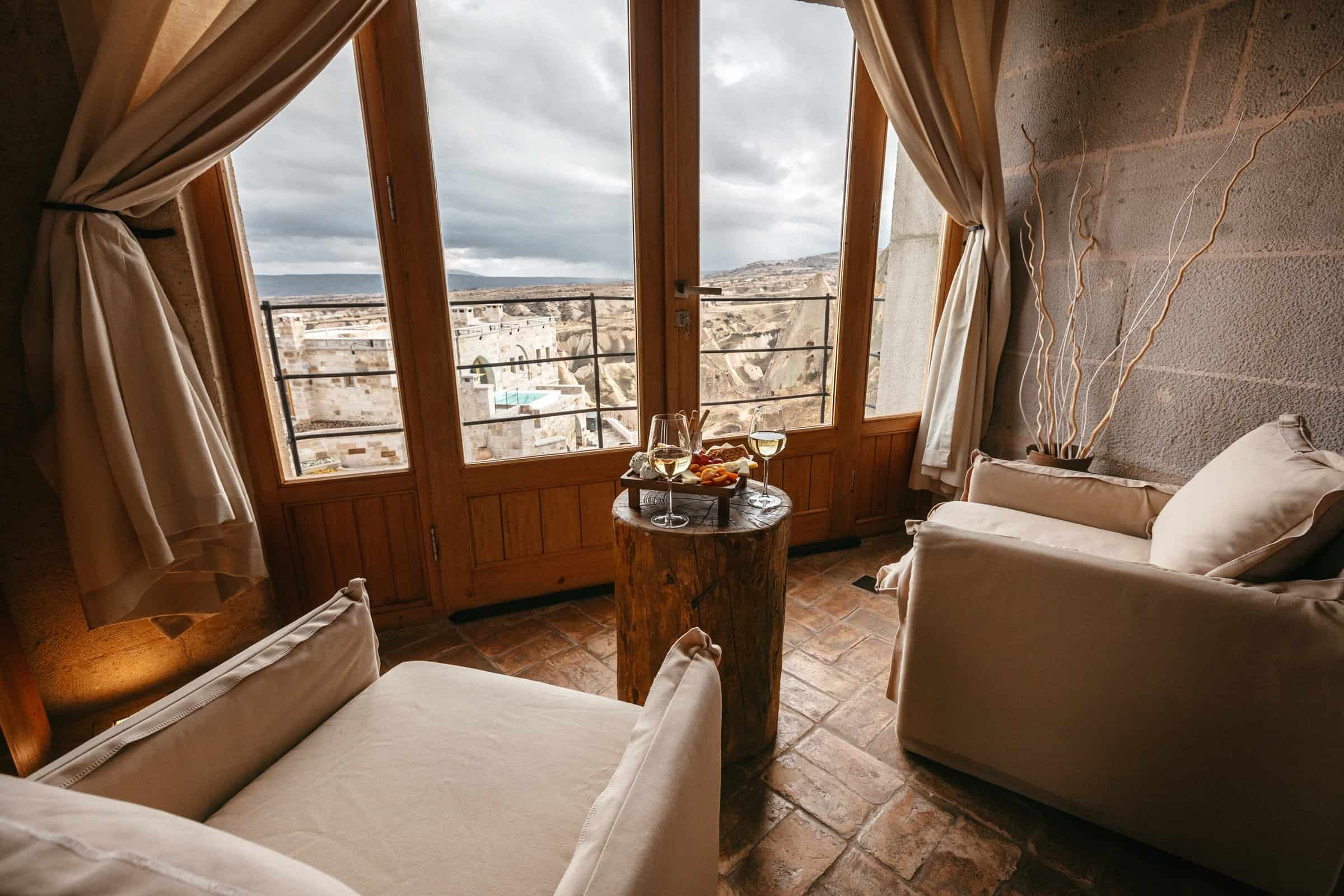 Suite With Balcony: seating area by large windows with a view over Uçhisar
