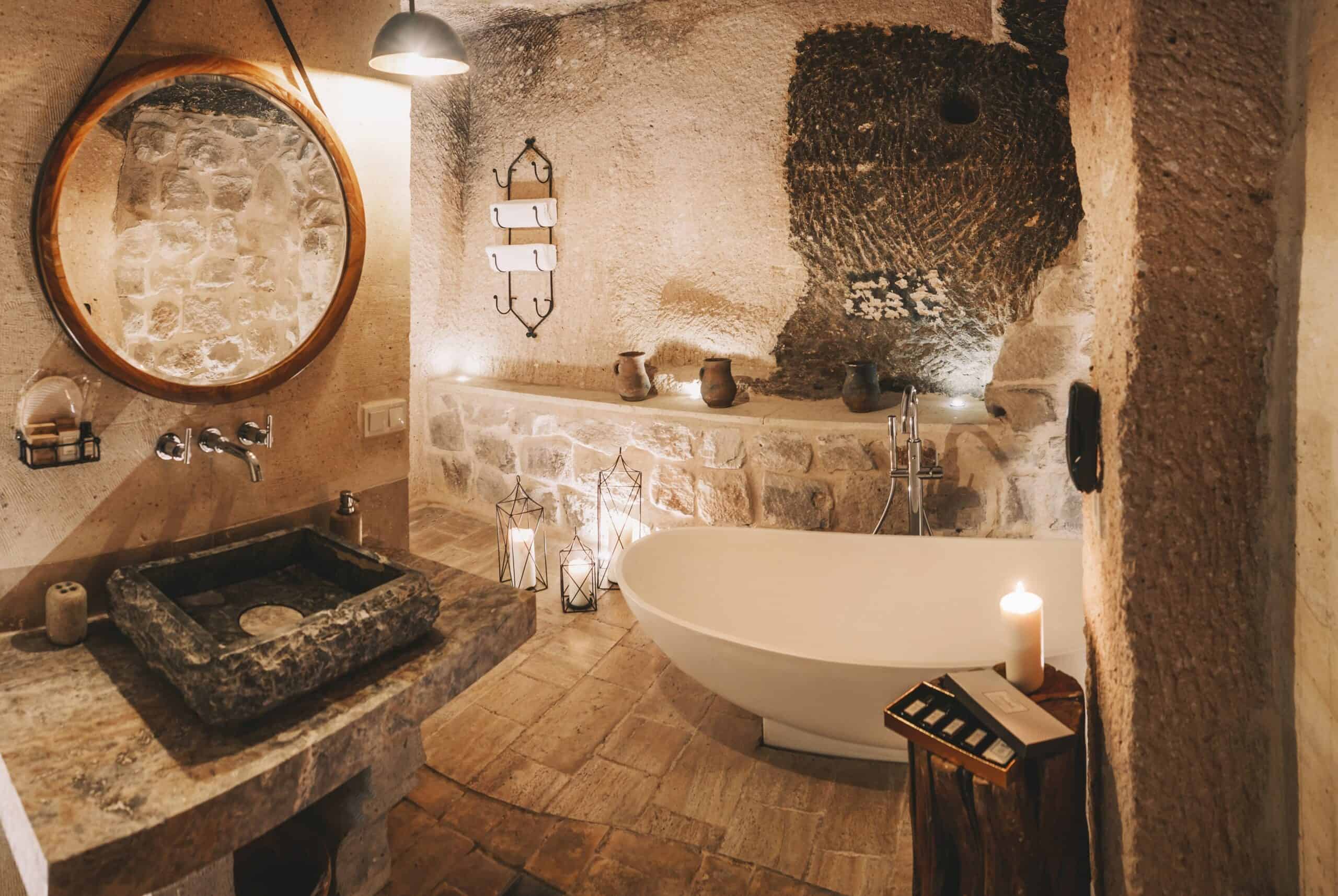 Superior King Suite: stone bathroom with freestanding bathtub and round mirror