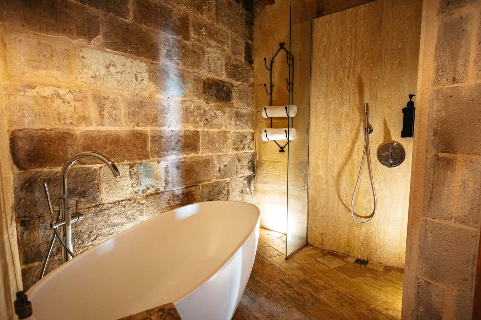 Suite With Balcony: freestanding bathtub and shower with stone walls