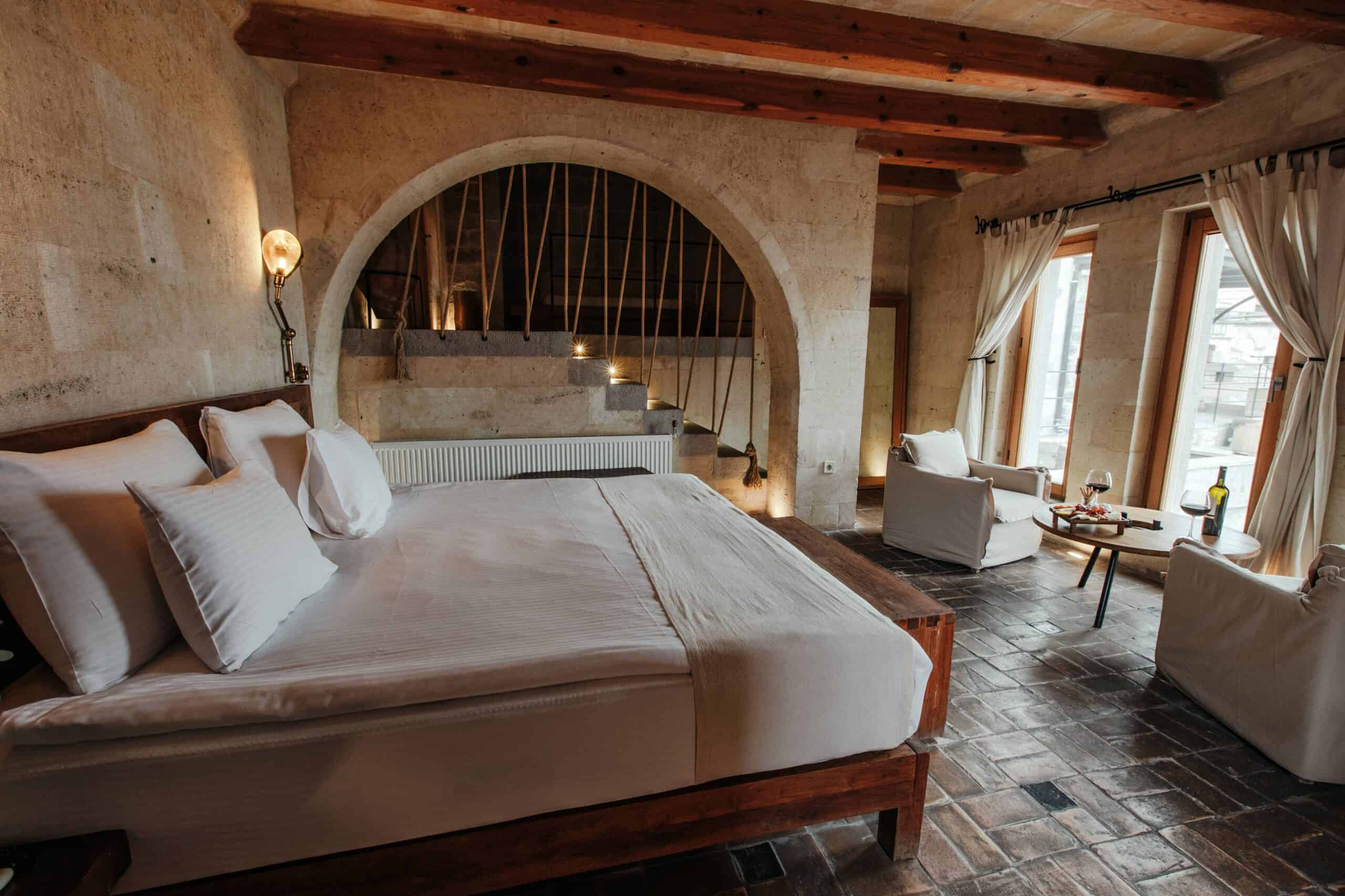 Suite With a View: bright room with double bed, sofa and arched window