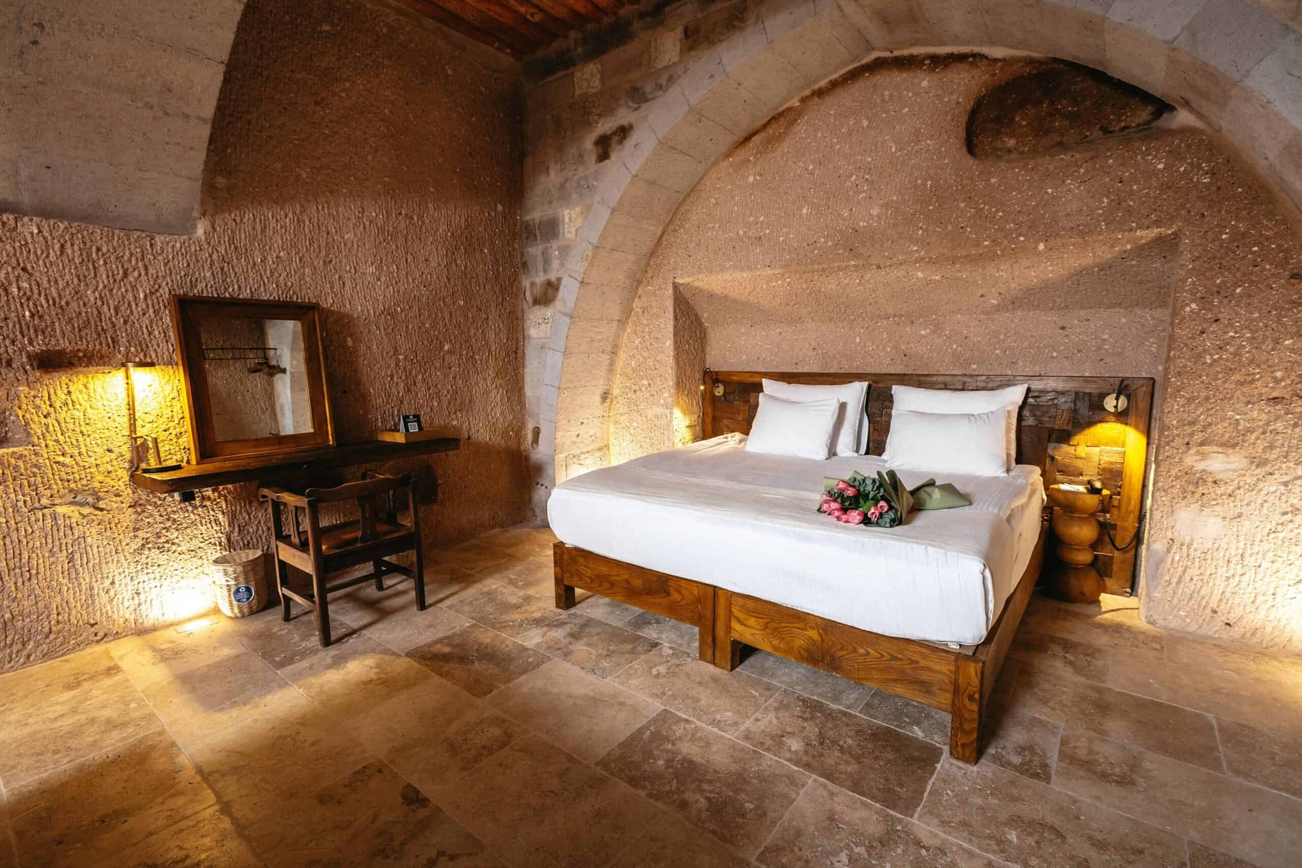 Superior King Suite: double bed under a stone cave arch