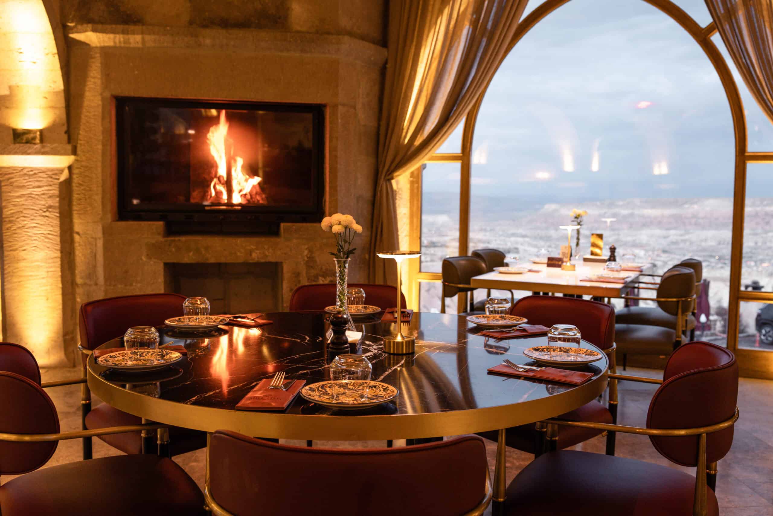 Mill Italy restaurant with fireplace and arched windows overlooking the valley