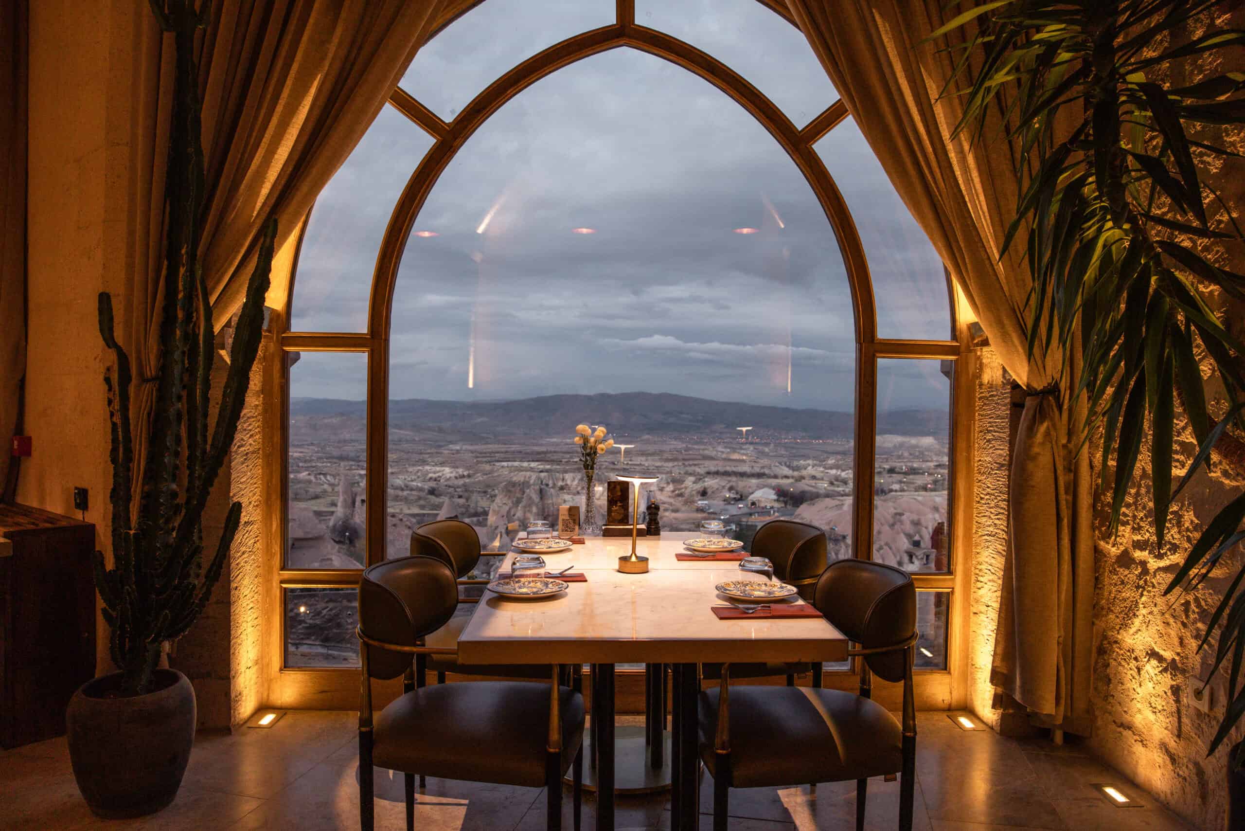 Table set by an arched window with a view over Cappadocia