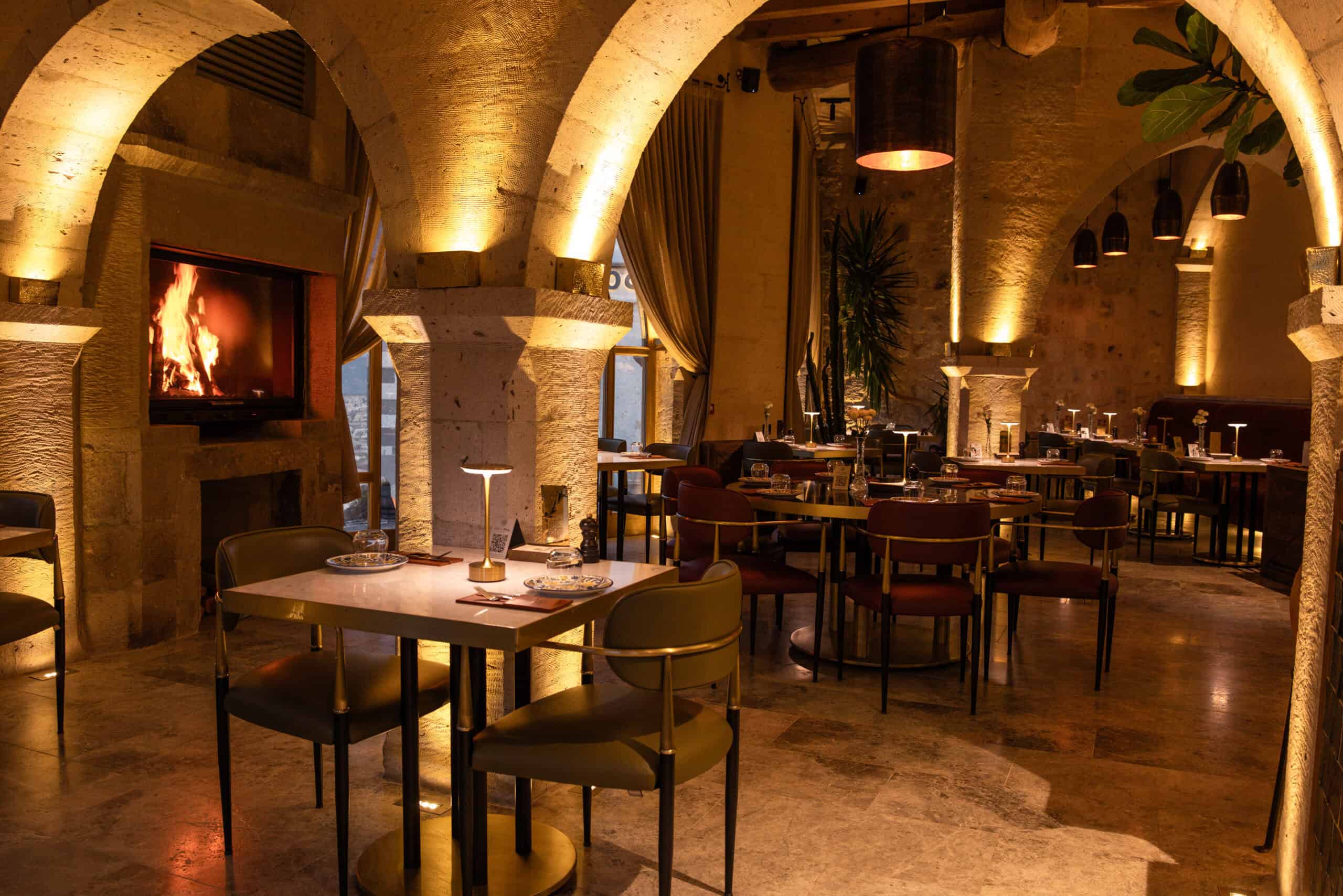 Mill Italy restaurant with fireplace, stone arches and set tables