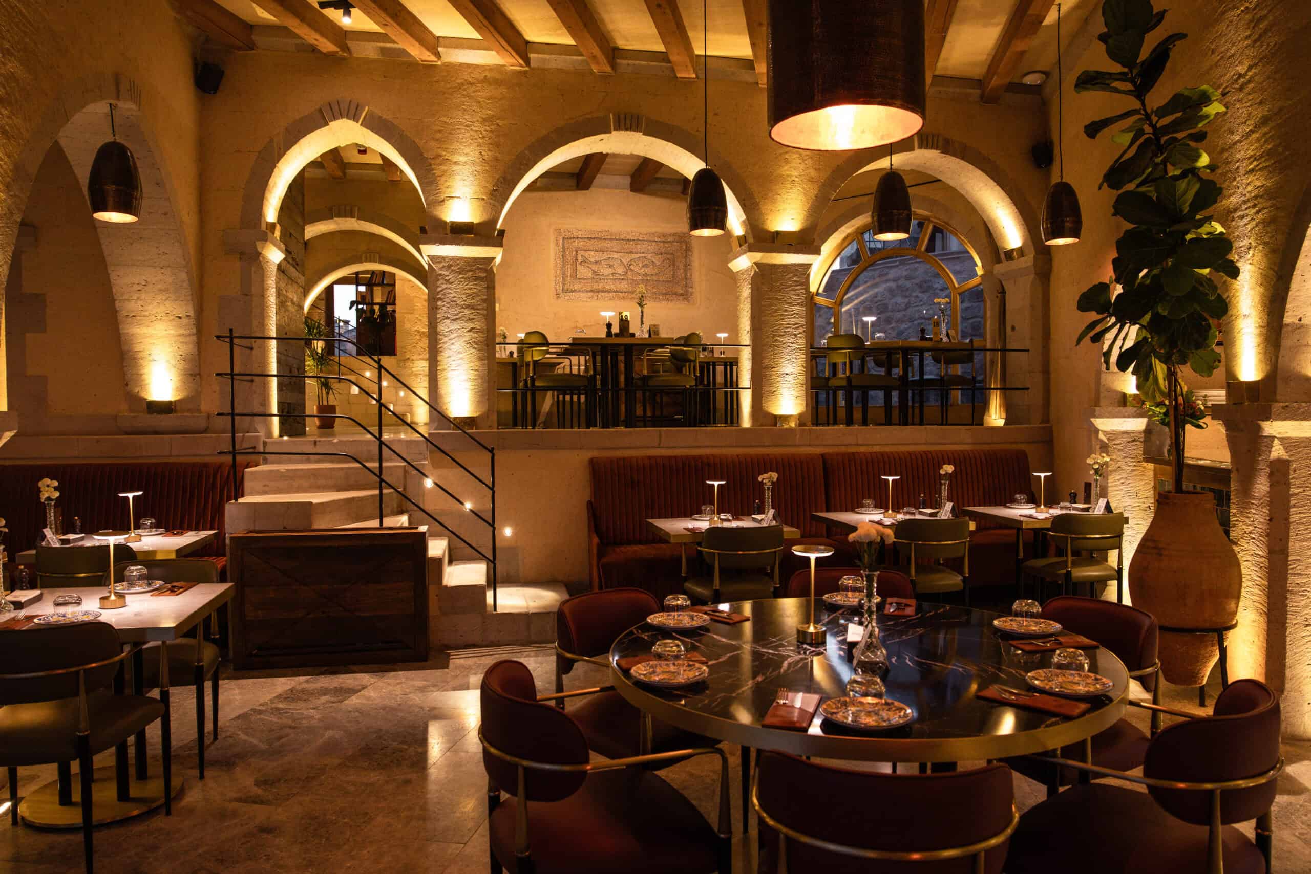 Mill Italy dining room with round tables under stone arches