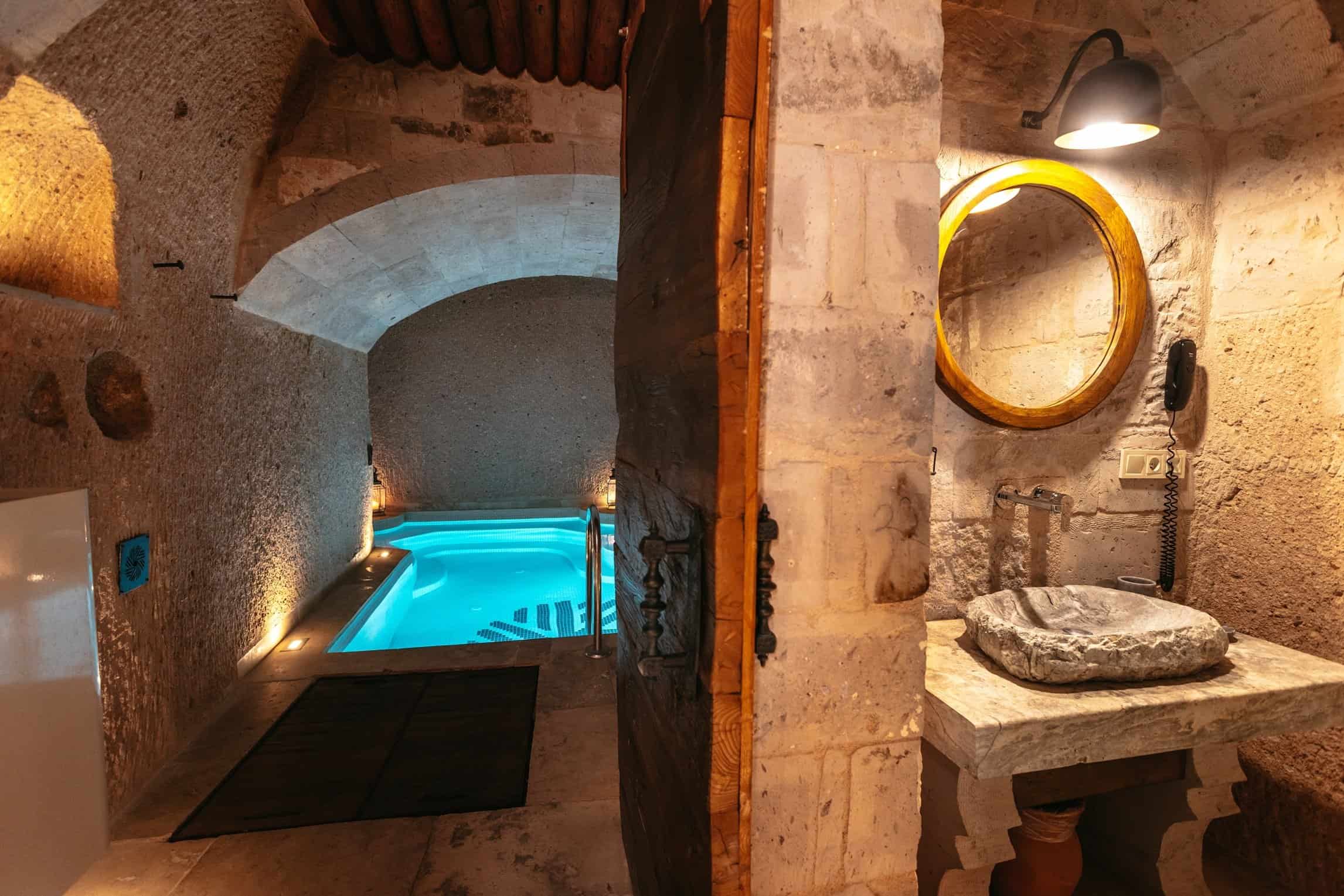 Pool Suite: small lit indoor pool next to the stone bathroom