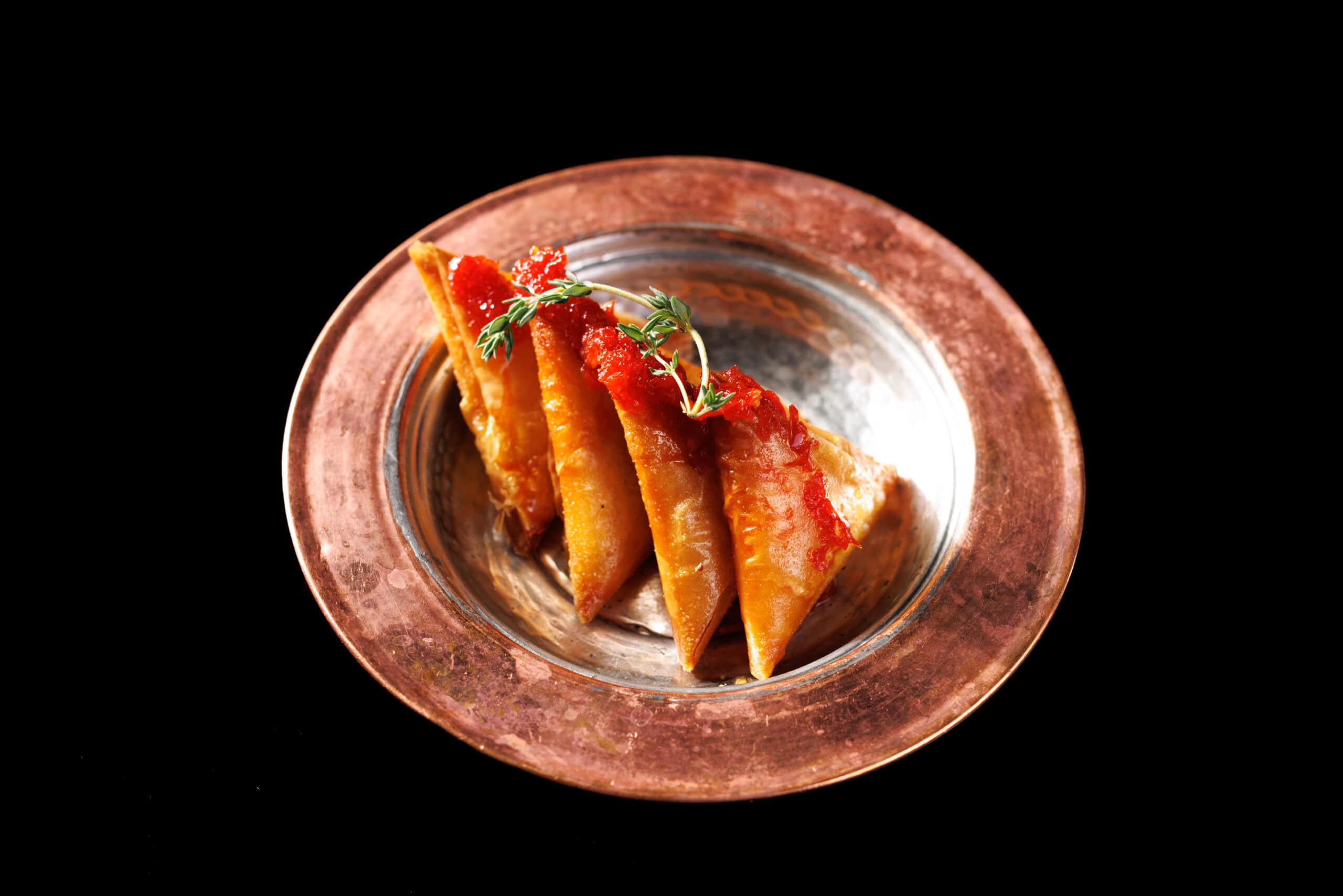 Anatolian dish with tomato sauce served on a copper plate