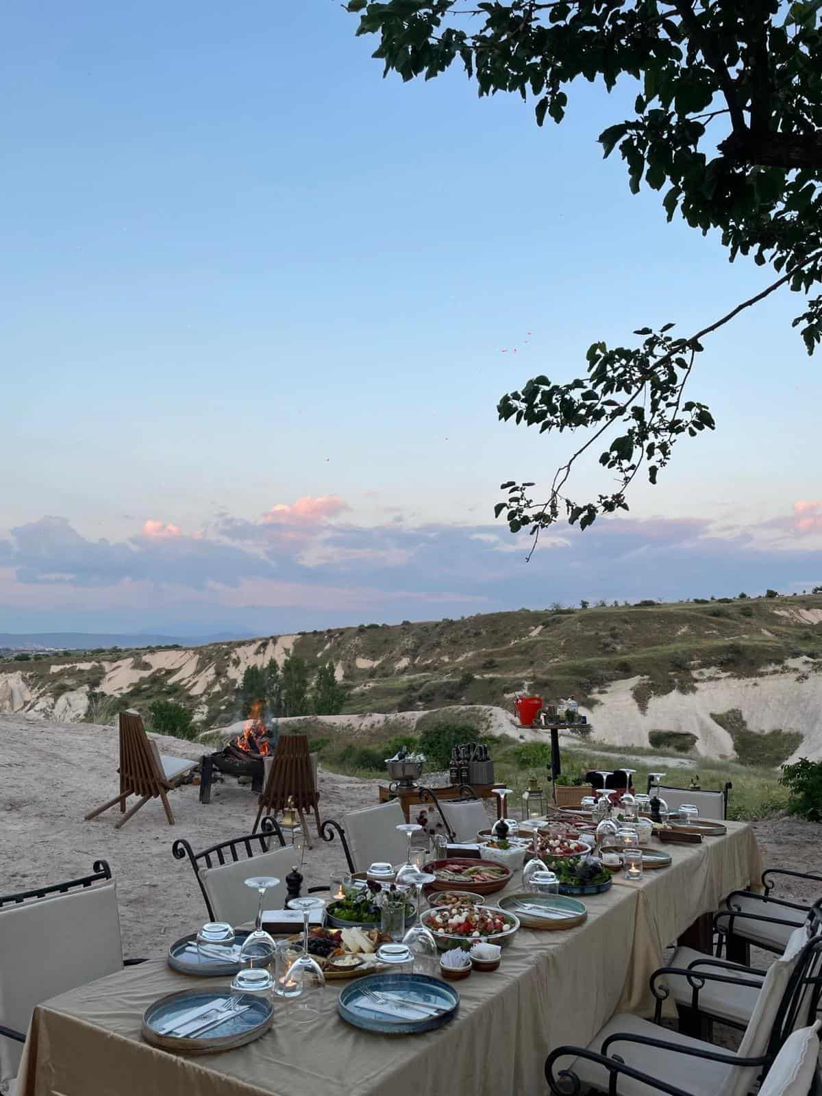 Long dinner table set outdoors with valley views