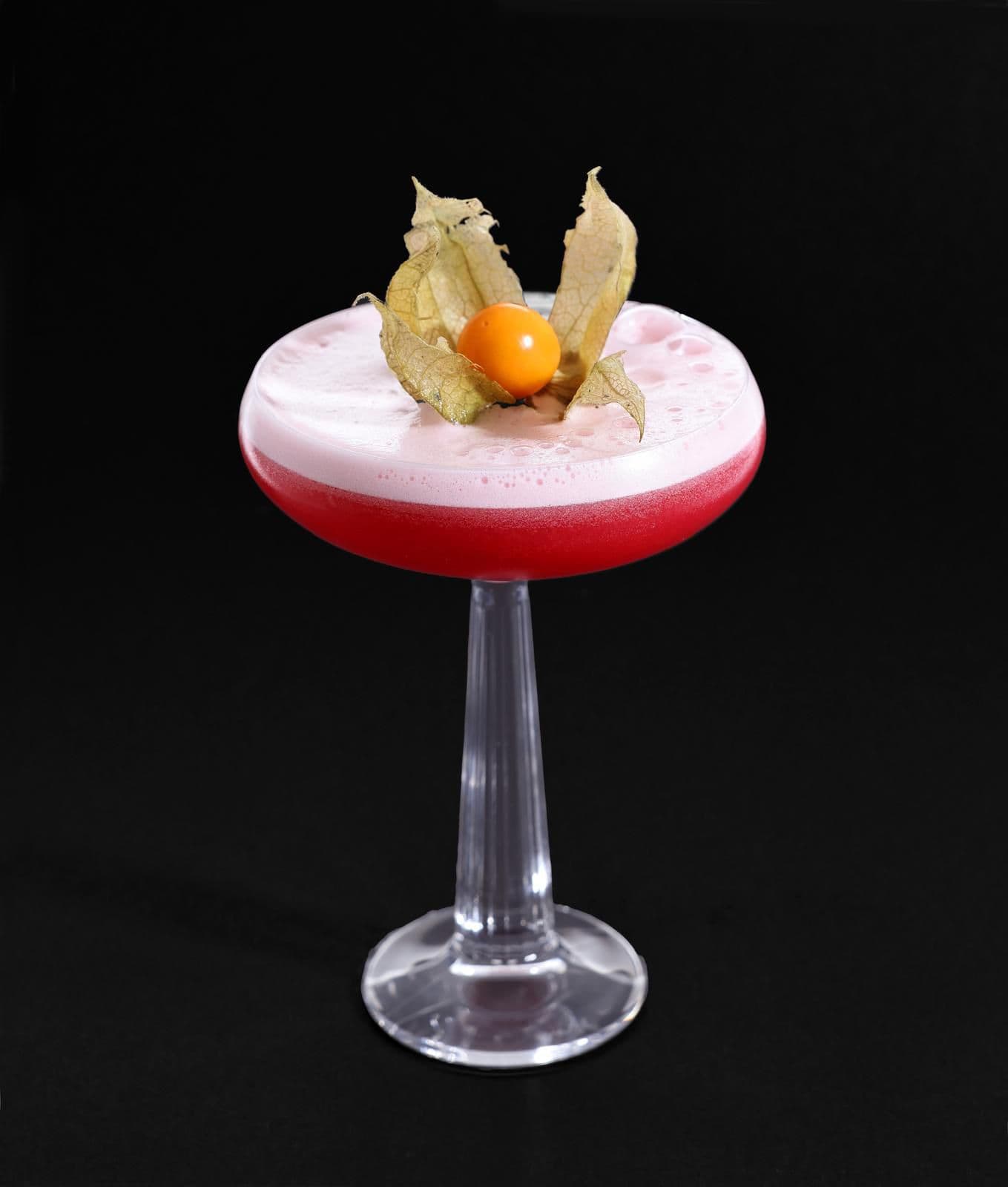 Pink signature cocktail with physalis garnish