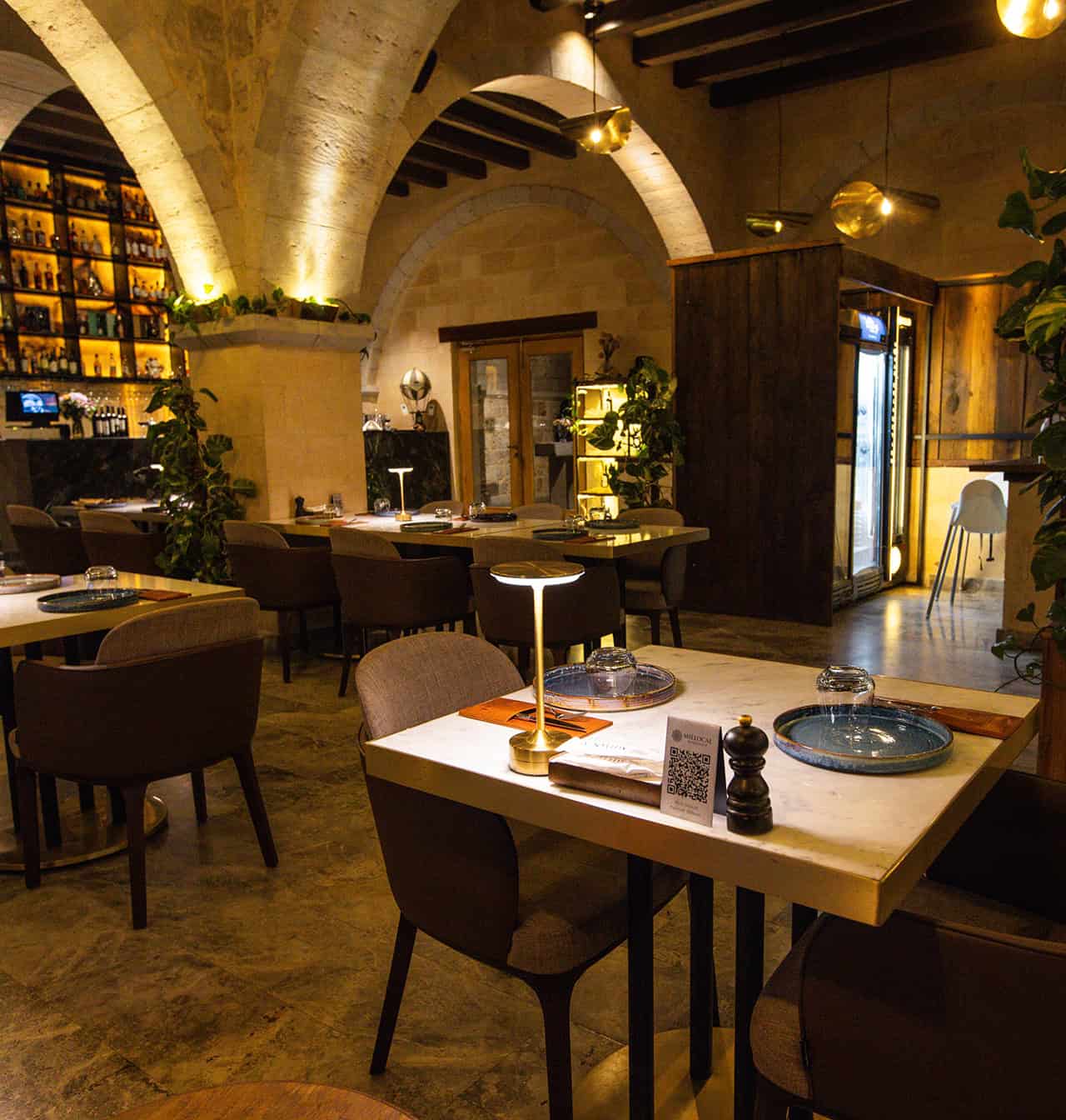 Millocal dining table under stone arches