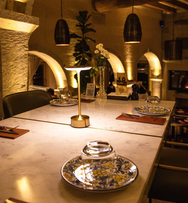 Mill Italy dining table with candle lamp under stone arches