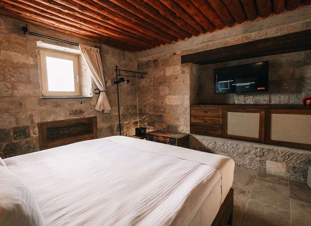 Standard Room with stone walls, wooden ceiling and double bed