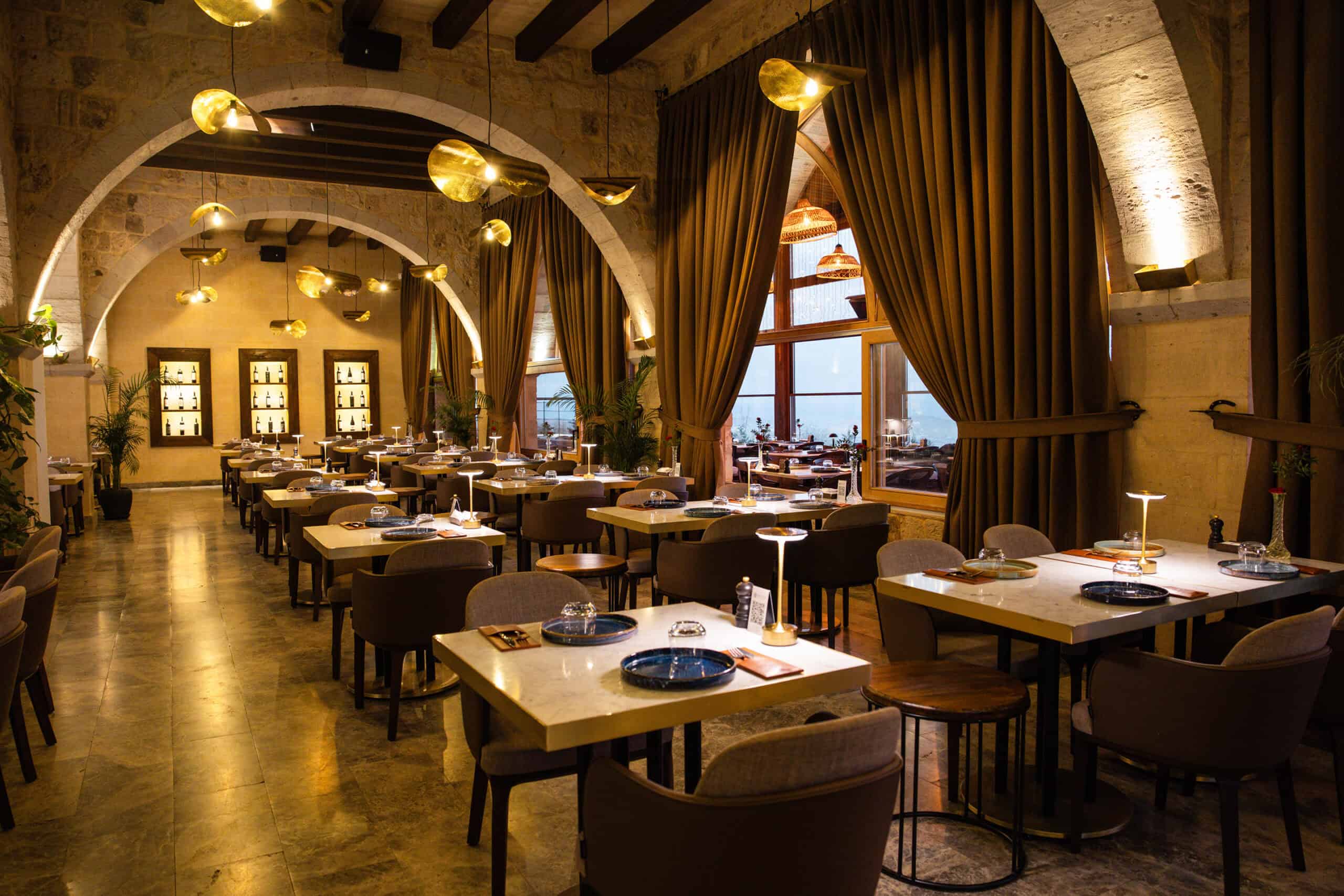 Millocal restaurant dining hall with stone arches and chandeliers