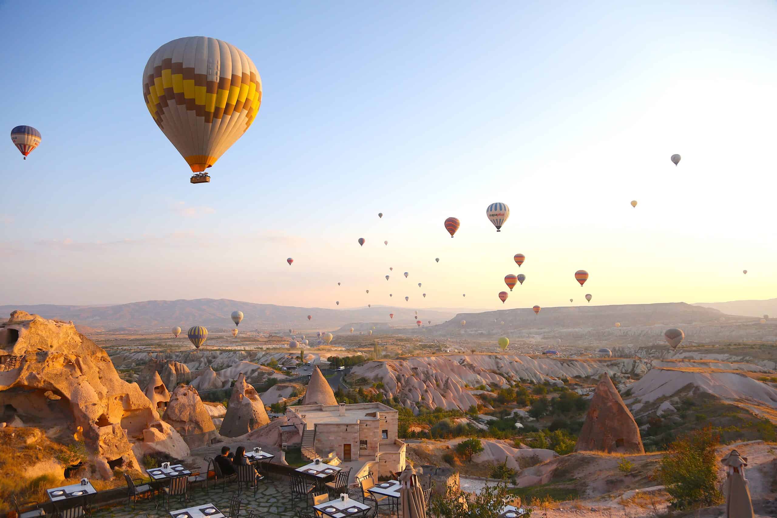 Hot air balloons rising over Cappadocia at sunrise